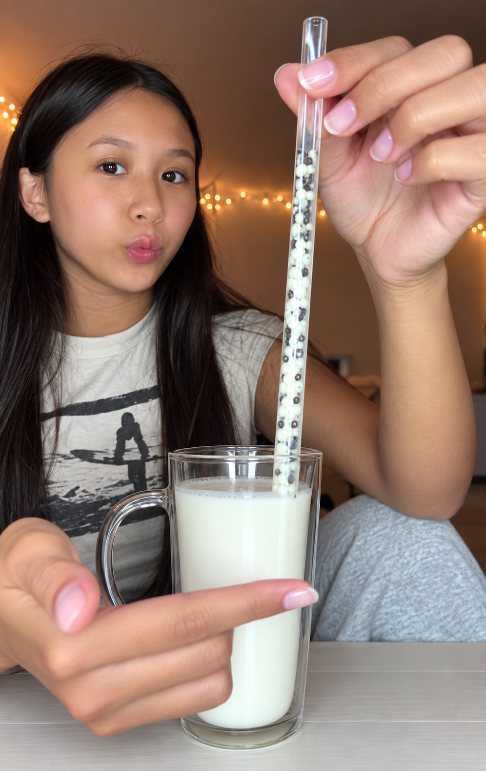 Girl dipping a candy-filled straw into a glass of milk