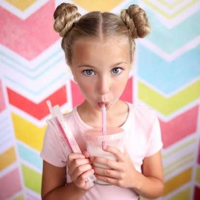 Girl with flavored straw against colorful background